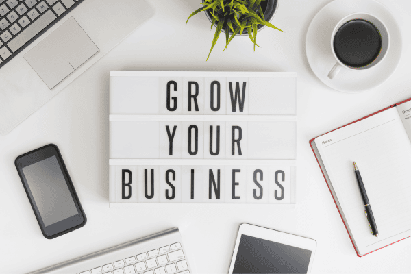 a desk with a sign that says grow your business