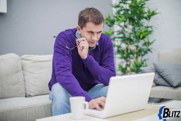 man working on laptop while on the phone